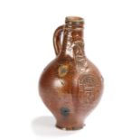 A 17th century stoneware pottery bellarmine jug, the speckled brown glaze with a bearded mask above
