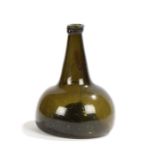 An early 18th century green glass 'onion' bottle, the lip above a conical shaped neck and bulbous
