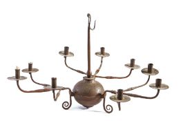 A wrought iron chandelier, the simple tapering shaft with suspension hook, terminating in a large