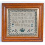 A William IV needlework sampler, circa 1830, with alphabet above an urn of flowers and two birds on