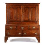 A George I oak press cupboard, South Wales, the rectangular top above a pair of doors with arched