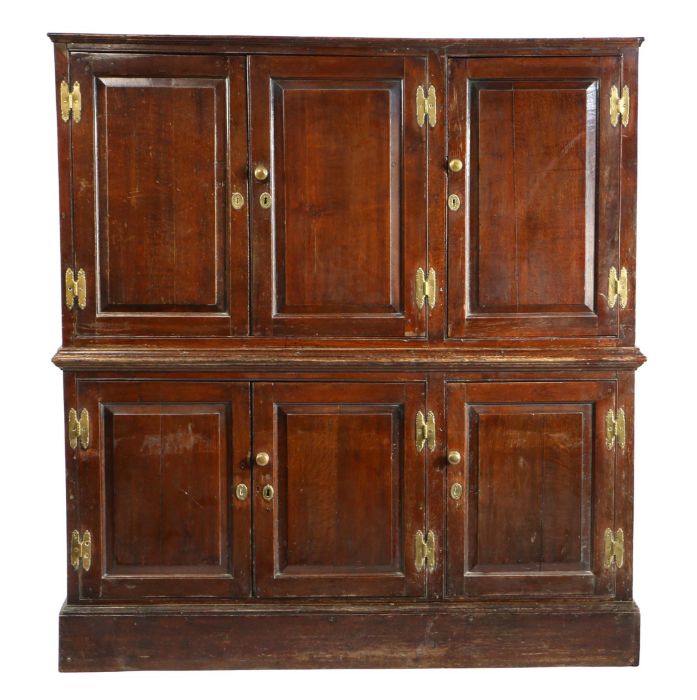 A George III oak cupboard, circa 1770, having six fielded panelled doors, a waist moulding and