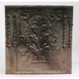 A cast iron fire back, dated '1555' over a central foliate spray, flanked by paired spiral split-