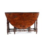 A William & Mary yew gateleg table, the oval drop-leaf top above  frieze drawers to either end, on