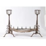 A pair of 18th/19th century cresset andirons, each with spit hooks and scroll decorated arched