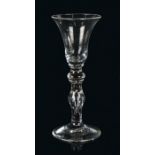An 18th Century wine glass, the trumpet bowl above a bulbous stem and conical foot, 17cm high
