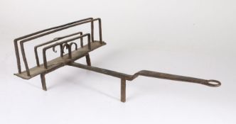 An 18th Century wrought iron rotating toast rack, the rectangular rotating end with twin bars