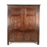 A Charles I joined oak press cupboard, West Country, circa 1640, with meandering floral carved top