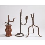 Three rushlight holders: a wrought iron example with U-shaped jaw and tripod base, 26cm high;