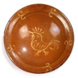 A Redware pottery dish, 19th Century or earlier, with slip decoration of a humming bird to the
