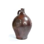 A good bellarmine stoneware jug, in brown glaze with a bulbous body and three medallions dated 1623,