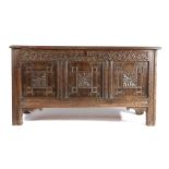 A Commonwealth  oak coffer, dated 1652, with triple-panelled hinged lid, the front again of three