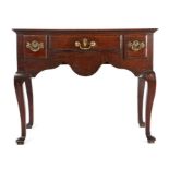 A George I oak lowboy, circa 1725, the rectangular top above three frieze drawers and shaped apron,
