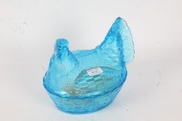 Bright blue pressed glass egg tureen, in the form of a chicken, containing four onyx, hardstone