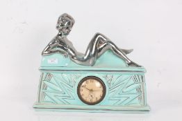 French Art Deco mantel clock, mounted with a silvered reclining lady above sunburst decoration on