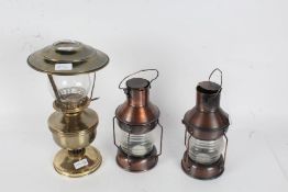 Pair of ships style copper effect candle lanterns, 24cm high, and a brass effect oil lamp (3)