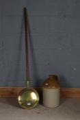 19th century long handled and brass warming pan, 134cm long, and a stoneware flagon, 40cm tall (2)