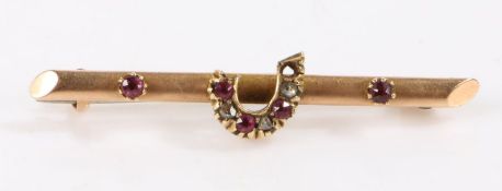 15 carat gold bar brooch set with a horse shoe with garnets and paste AF, weight 1.6 grams