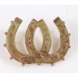 9 carat gold brooch in the form of two interlocking horse shoes with floral decoration, weight 1.8