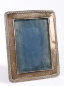 George V silver picture frame, with scroll embossed border and easel back, 14cm x 18cm