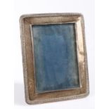 George V silver picture frame, with scroll embossed border and easel back, 14cm x 18cm