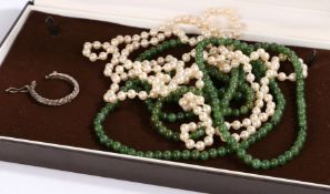 Pearl necklace together with a green stone necklace and a single white metal earring housed in