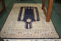 Turkish wool prayer rug, centred with navy blue medallion within a light blue, beige and yellow