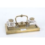 Late Victorian brass desk stand with two ink wells with brass caps and a pot to the center with a
