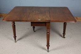 Victorian mahogany drop leaf table, the round cornered top raised on turned legs and brass