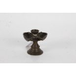19th Century Indian bronze butter lamp, the dished circular top flanked by two oval wells, raised on