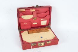 Early 20th century red leather travelling case, the outer case with a red covering and red leather