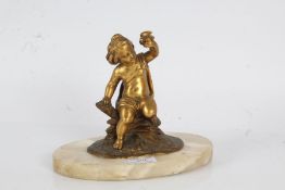 19th Century gilt bronze figure depicting a young boy seated on a log holding a small bird aloft, on
