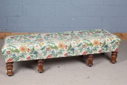 Long floral upholstered stool, raised on front pine baluster legs and plank back legs, 161cm long,