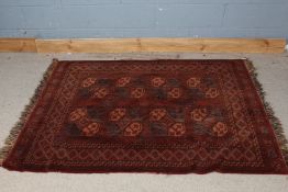 Middle Eastern wool rug, centred with a geometric pattern within a cross framed border, tasselled