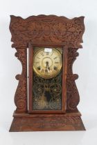 Late 19th/early 20th century American kitchen or mantel clock, having press moulded 'Gingerbread'