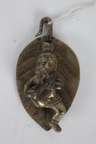 Indian silvered metal deity, possibly depicting infant Krishna laying on a leaf, 7.5cm wide, 13.