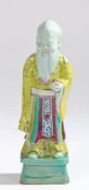 Chinese pottery figure, with bright yellow, green and blue glazed decorations standing on a