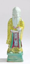 Chinese pottery figure, with bright yellow, green and blue glazed decorations standing on a