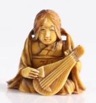 Japanese ivory netsuke, Meiji period, carved as a seated figure laying an instrument, 35mm high