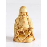 Japanese ivory netsuke, Meiji period, carved as a seated scholar, signed to the underside of the