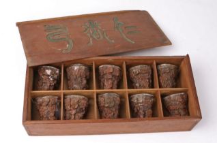Cased set of ten Chinese carved wood and silver lined Libation cups, each with a dished silver liner