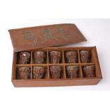 Cased set of ten Chinese carved wood and silver lined Libation cups, each with a dished silver liner