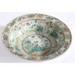 Chinese Canton porcelain punch bowl, Qing Dynasty, with a muted green ground and colourful panels