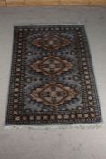 Middle Eastern rug, the blue and cream ground with three diamond lozenges and floral decoration,