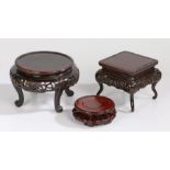 Three Chinese stands, the first example with a square top with an edge carved with bats and scrolls,