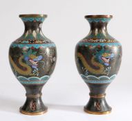 Pair of Chinese cloisonné vases, each with two dragons and a black ground, 24cm high, (2)