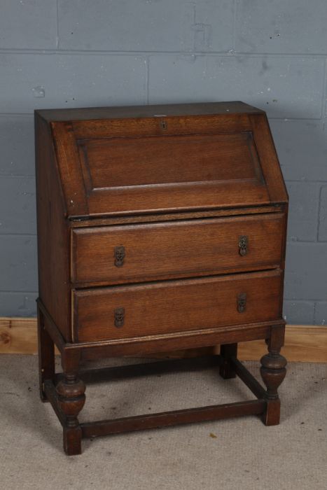 20th century oak bureau, the sloping front enclosing a fitted interior, fitted two long drawers