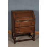 20th century oak bureau, the sloping front enclosing a fitted interior, fitted two long drawers