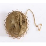 A cameo brooch made from carved lava, set a yellow metal with a safety chain. Weighing 26 grams.