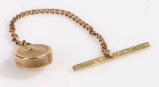 A circular 9 carat yellow gold pendant with a T-bar on a short chain, weighing 1.3 grams.